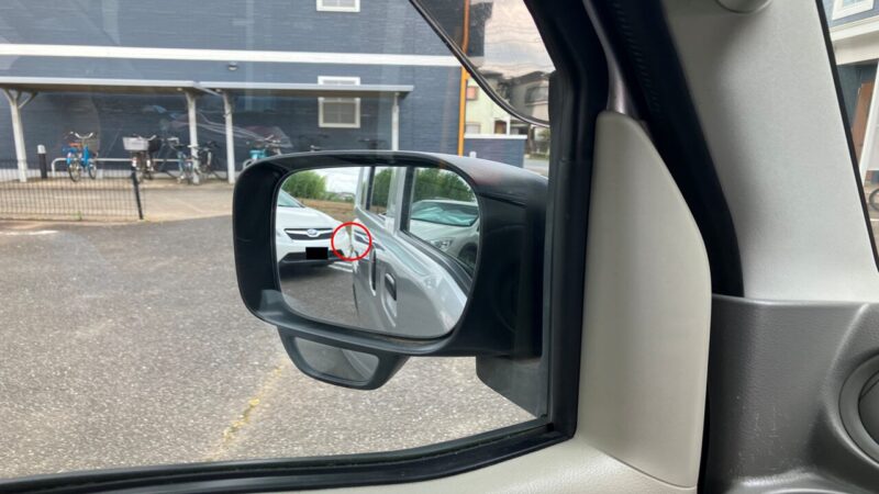 左バックでハンドルを切りすぎた時のサイドミラーの様子。車体の軌道と左隣の車が重なっていることを赤丸で注意喚起している。