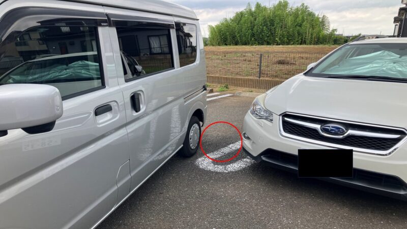 左バック駐車が成功した状態を外側から撮影した写真。自車と左隣の車の間に十分な余裕があり、寄せすぎていないことが分かる。